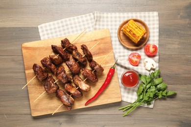 Delicious shish kebabs served on wooden table, flat lay