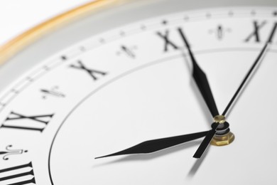 Photo of Stylish round clock on white background, closeup. Interior element