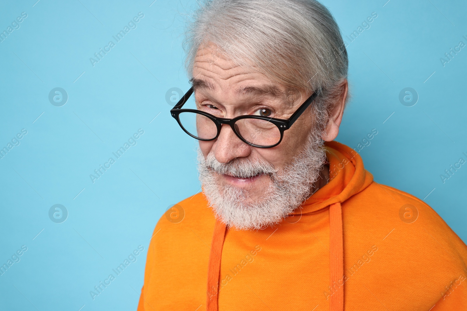 Photo of Senior man with mustache on light blue background, space for text