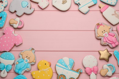 Frame of baby shower cookies on pink wooden table, flat lay. Space for text