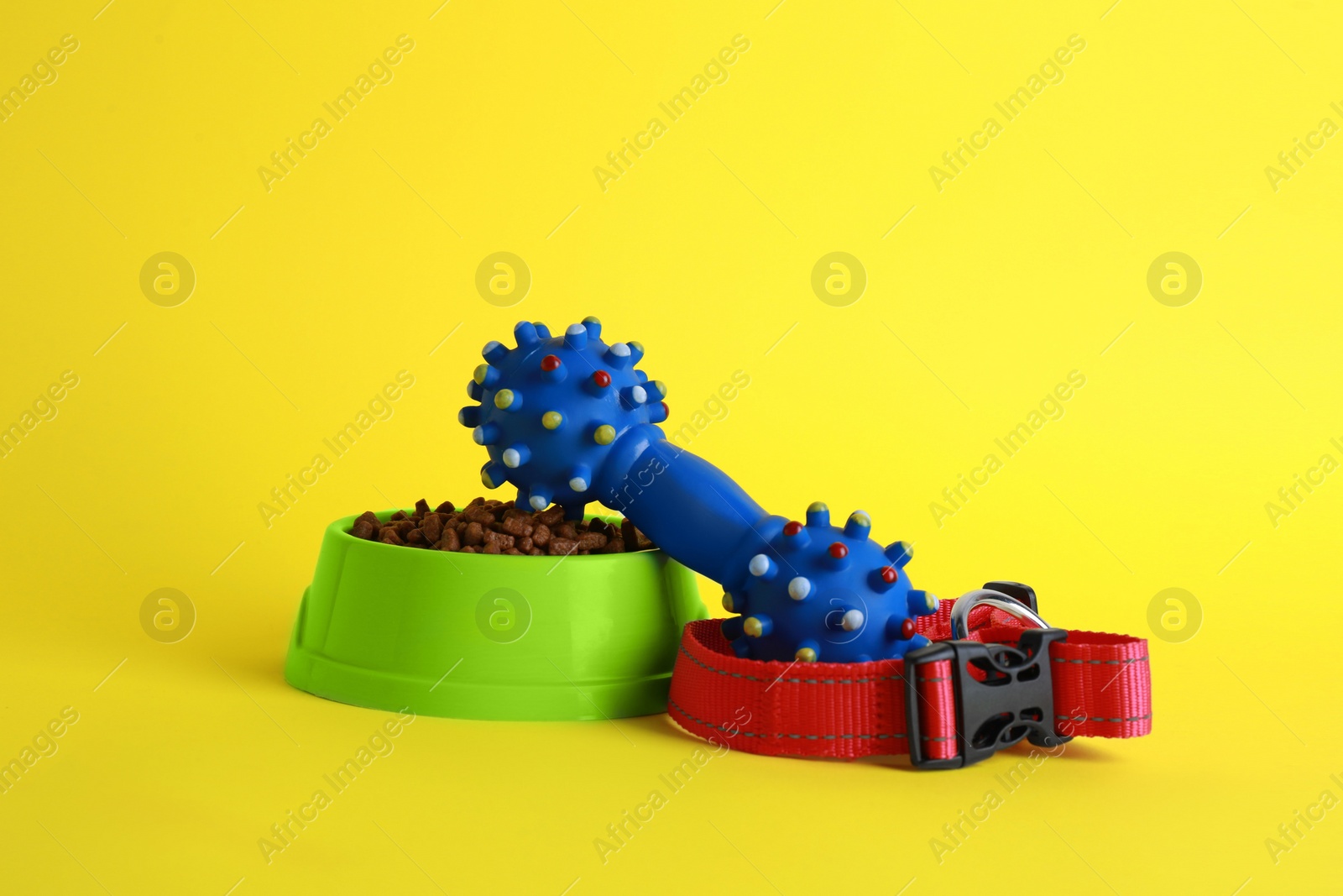 Photo of Pet toy, collar, food and feeding bowl on yellow background