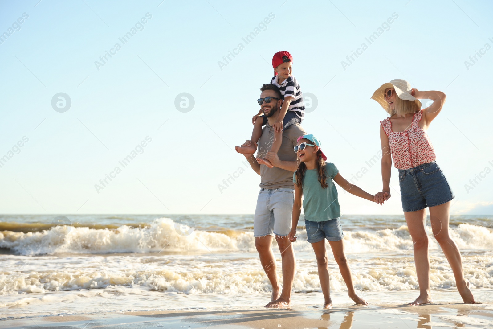 Photo of Happy family on sandy beach near sea