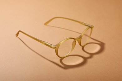 Photo of Glasses with corrective lenses on light brown background