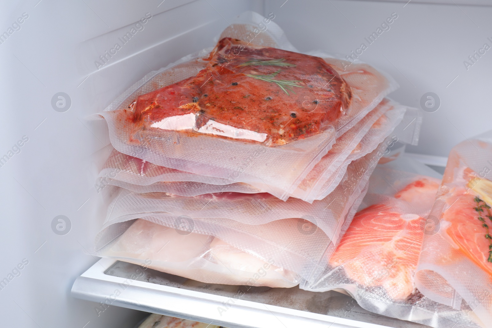 Photo of Vacuum bags with different products in fridge. Food storage