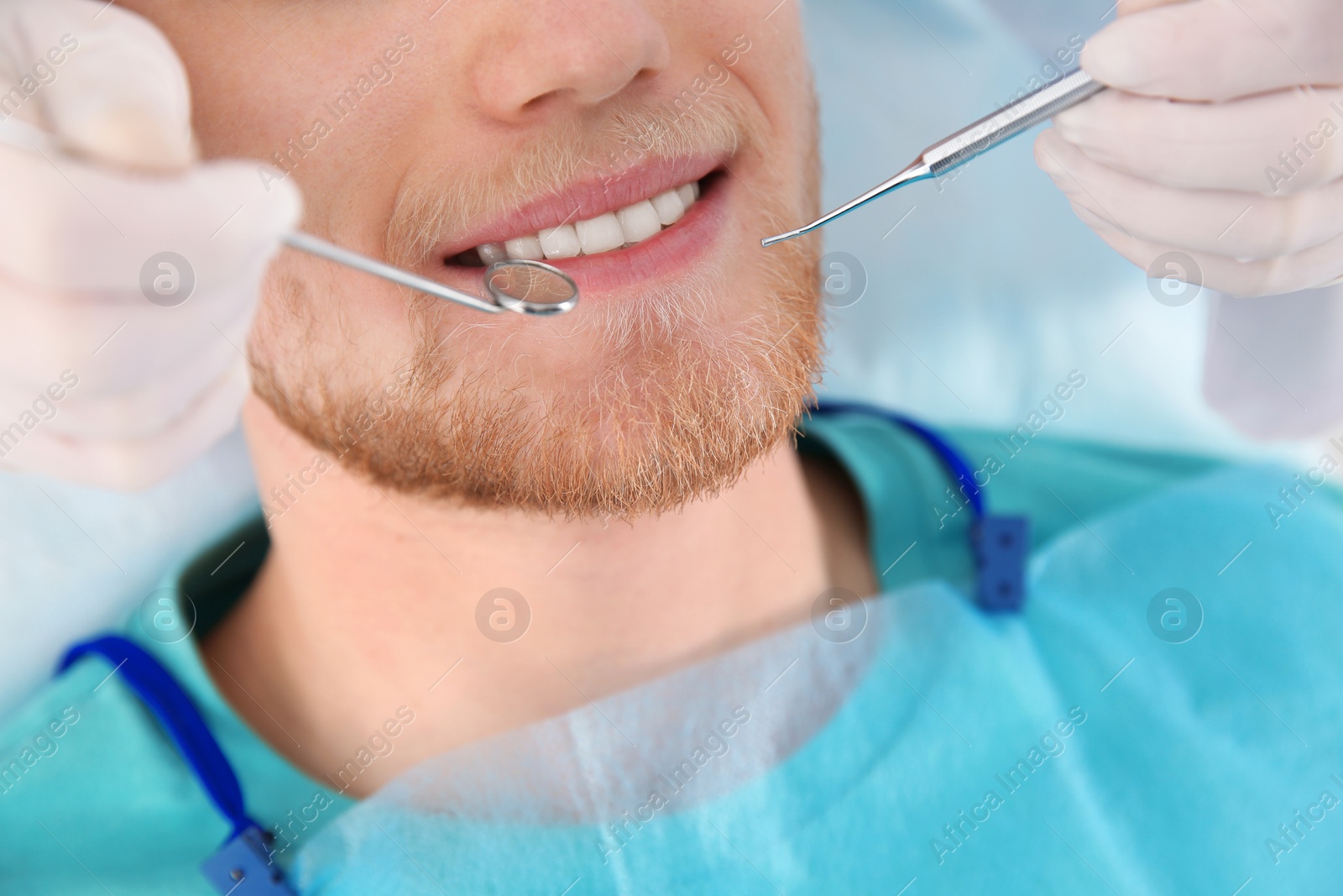 Photo of Dentist examining patient's teeth in modern clinic, closeup