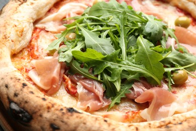Photo of Tasty pizza with meat and arugula, closeup view