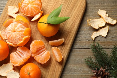 Photo of Flat lay Christmas composition with fresh tangerines and fir tree branches on wooden table