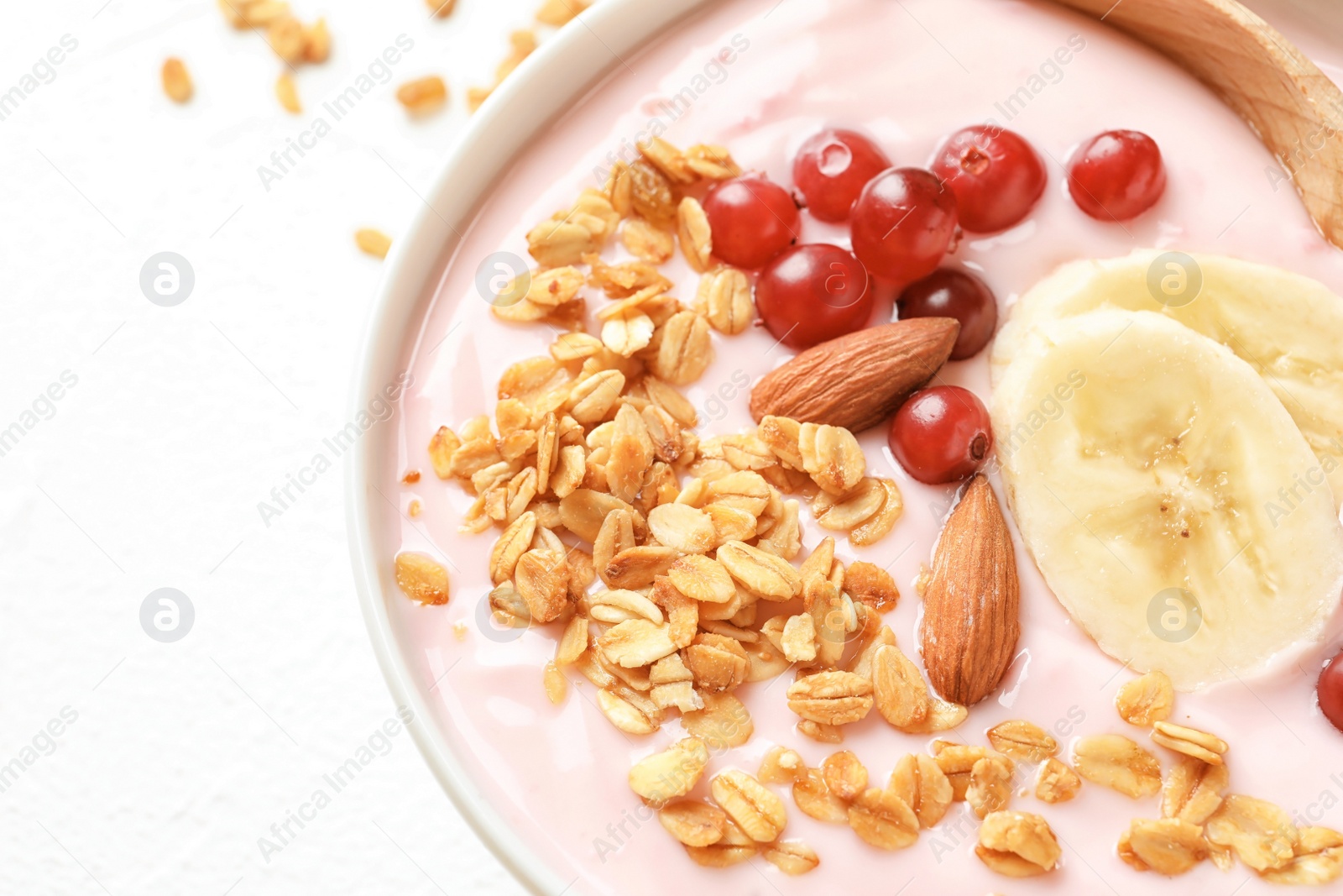 Photo of Bowl with delicious yogurt and granola, closeup