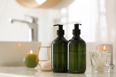 Photo of Green soap dispensers on countertop near sink in bathroom. Space for text