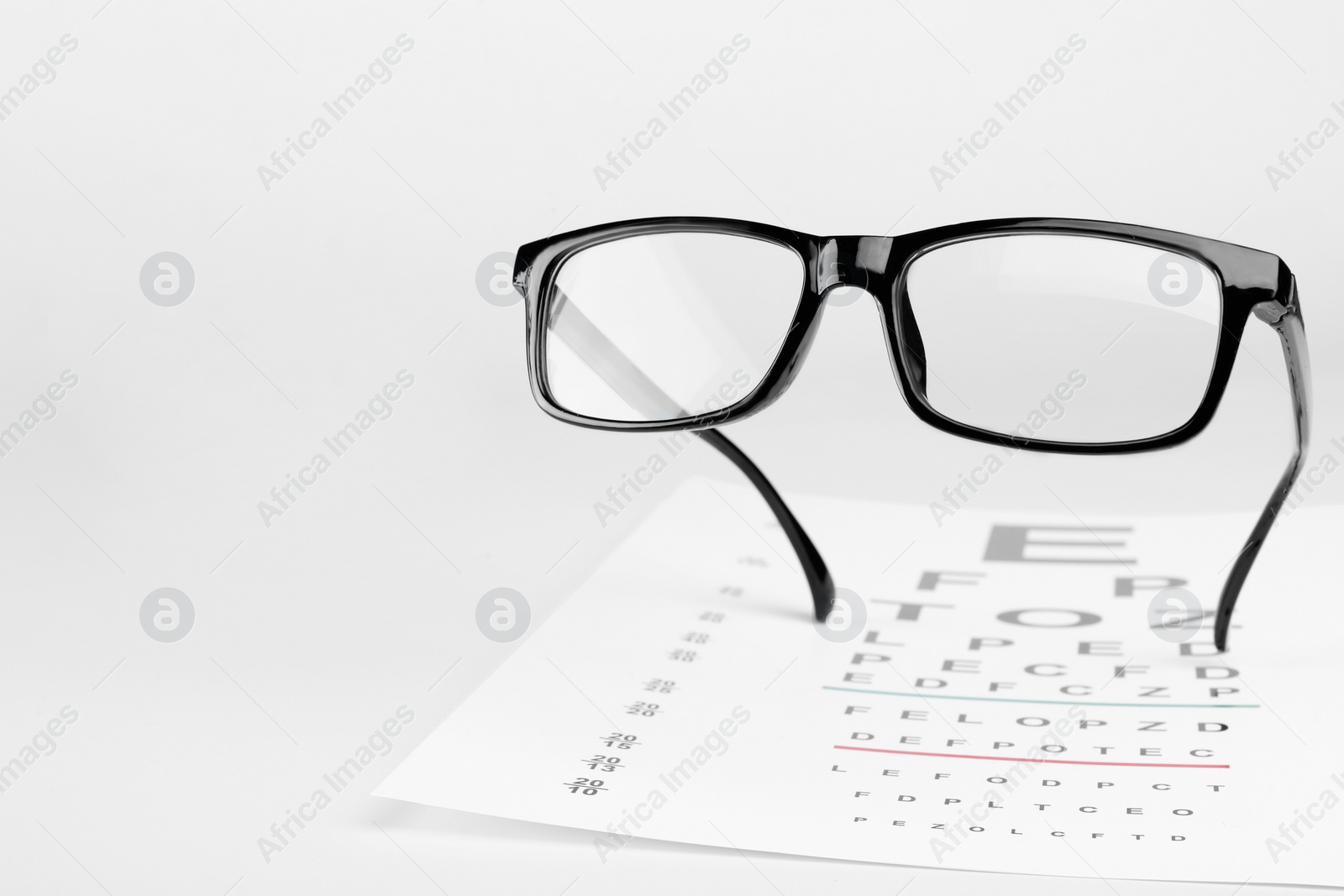 Photo of Glasses and vision test chart isolated on white