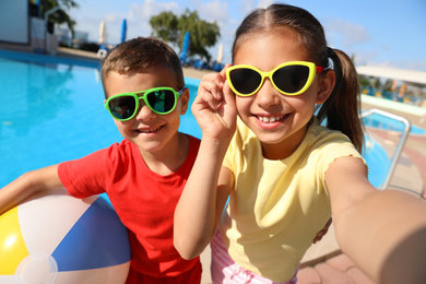 Photo of Happy children taking selfie near swimming pool. Summer vacation
