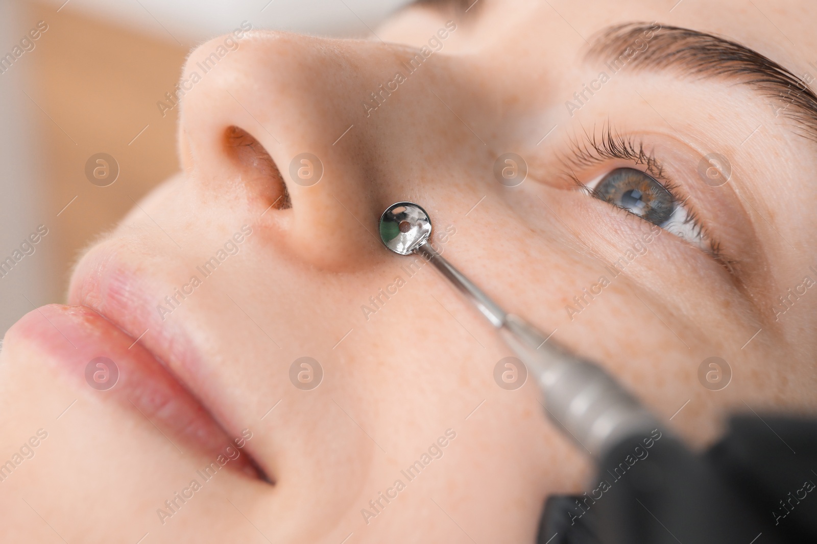 Photo of Cosmetologist using scrubber, closeup. Client having cleansing procedure