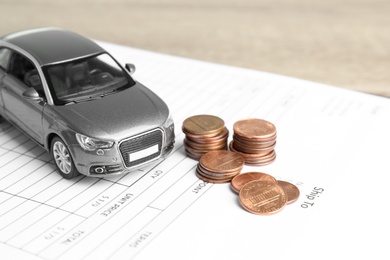 Toy car, money and insurance contract on table