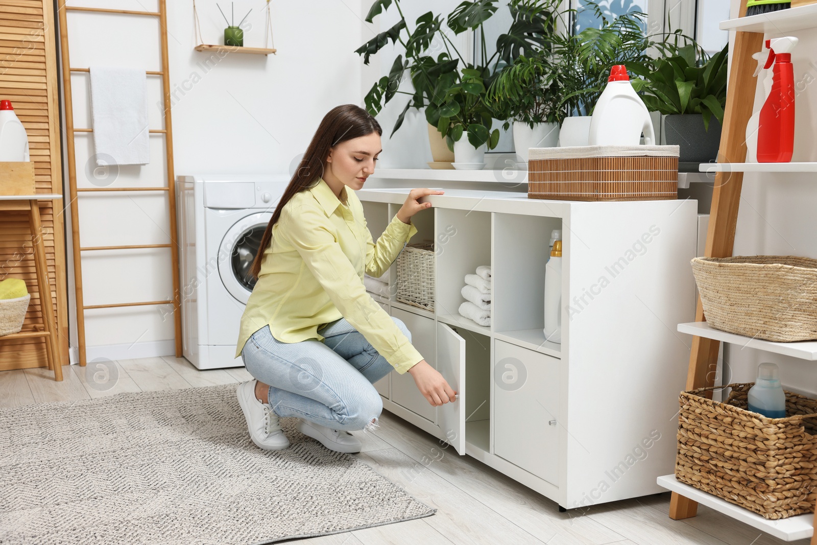 Photo of Beautiful young woman in modern laundry room