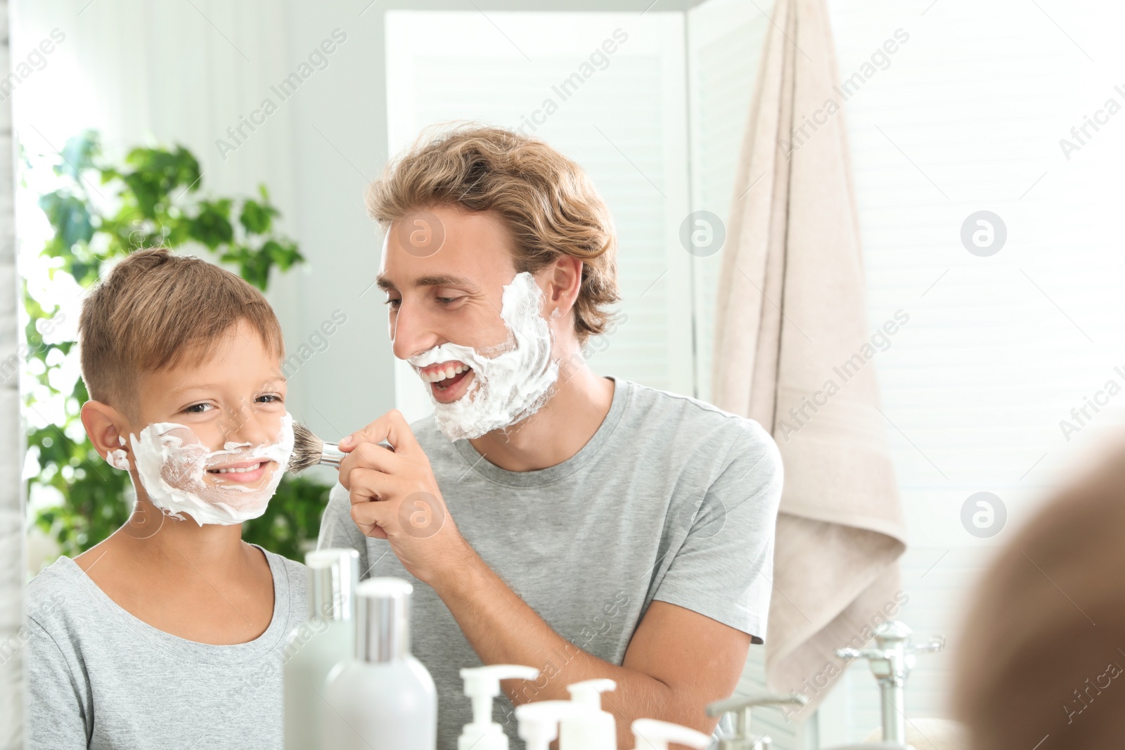 Photo of Father and son shaving together in bathroom