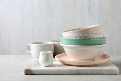 Photo of Different dishware and marble board on table