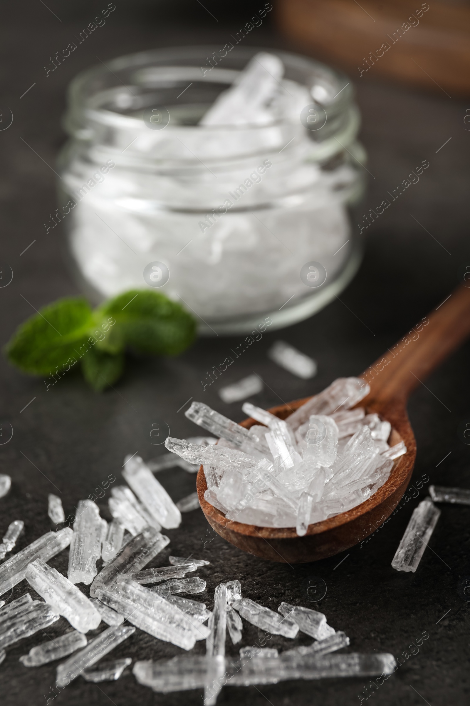 Photo of Menthol crystals in spoon on grey background, closeup