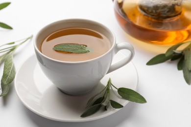 Photo of Aromatic herbal tea with sage on white table