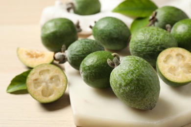 Photo of Fresh green feijoa fruits on light table, closeup