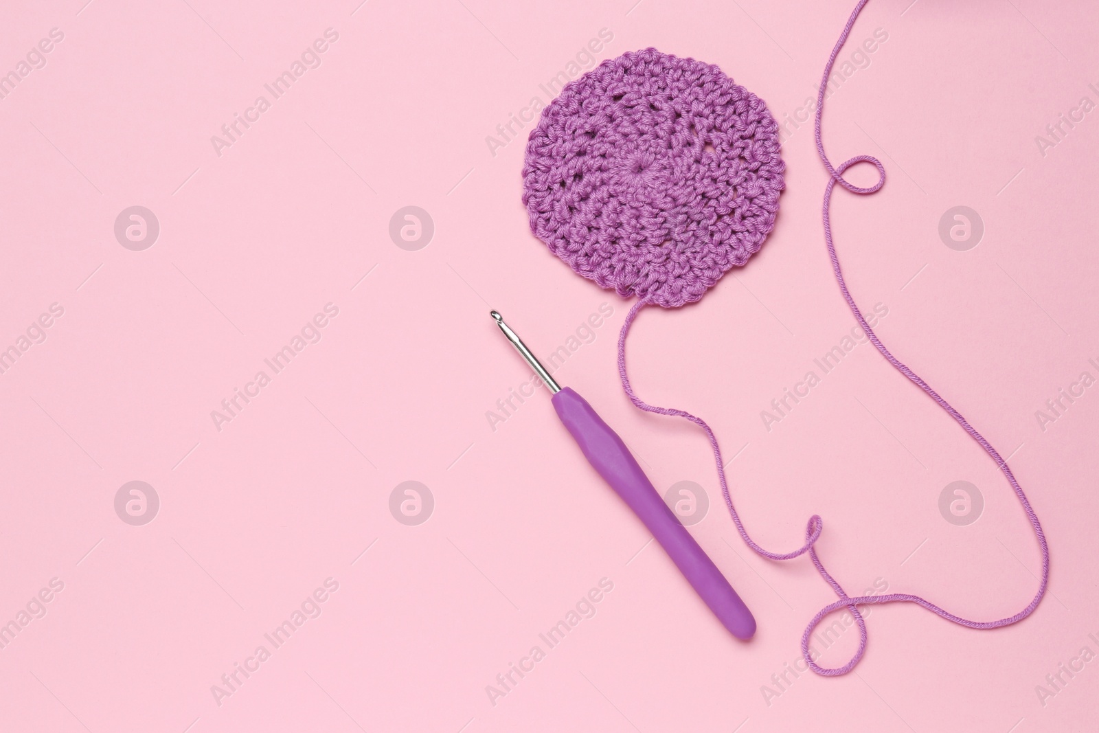 Photo of Knitting and crochet hook on pink background, flat lay. Space for text