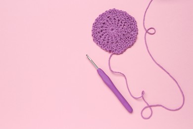 Photo of Knitting and crochet hook on pink background, flat lay. Space for text