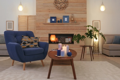 Photo of Burning candles on table in living room