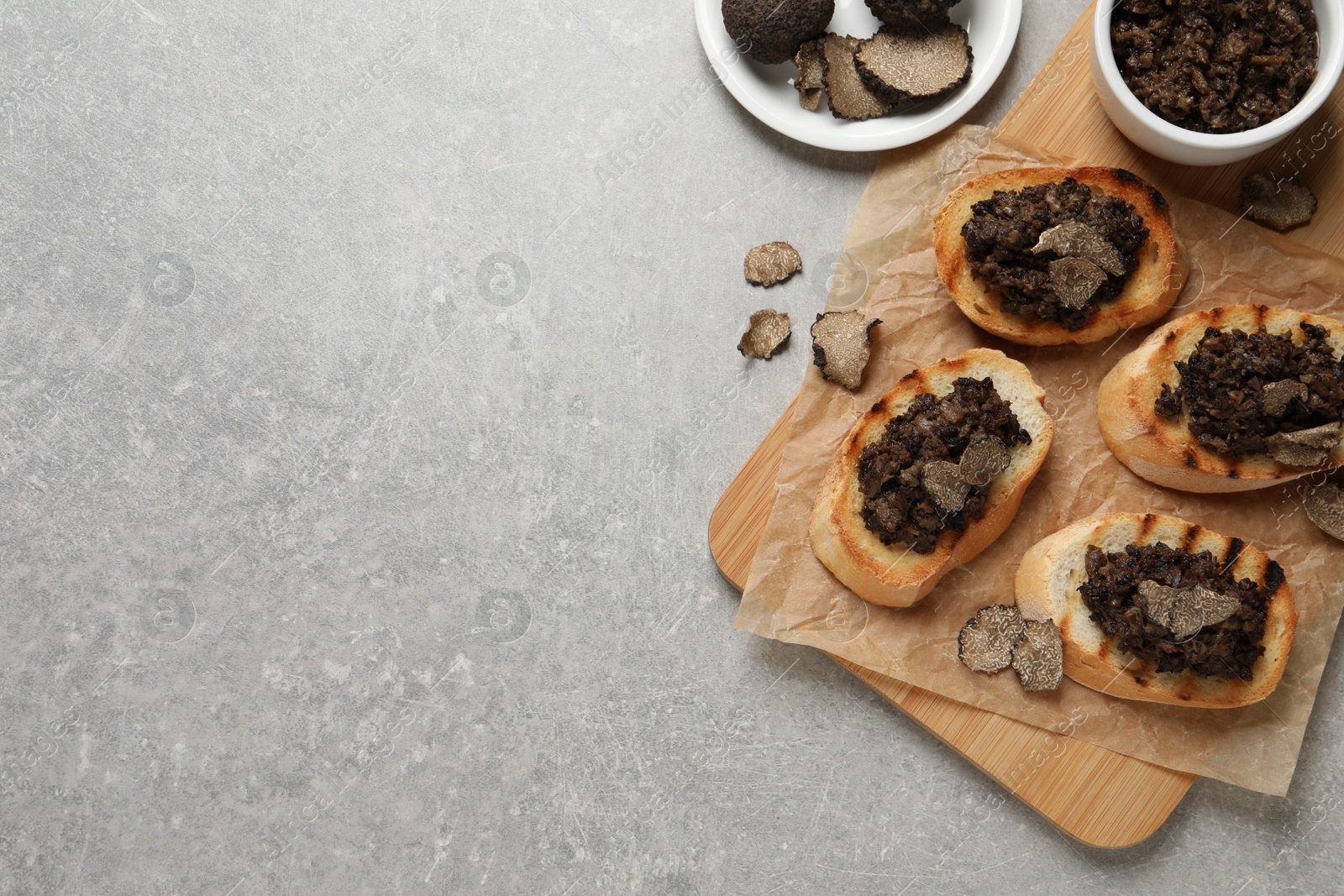 Photo of Delicious bruschettas with truffle sauce on light grey table, flat lay. Space for text