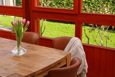 Photo of Wooden table and chairs with blanket on terrace