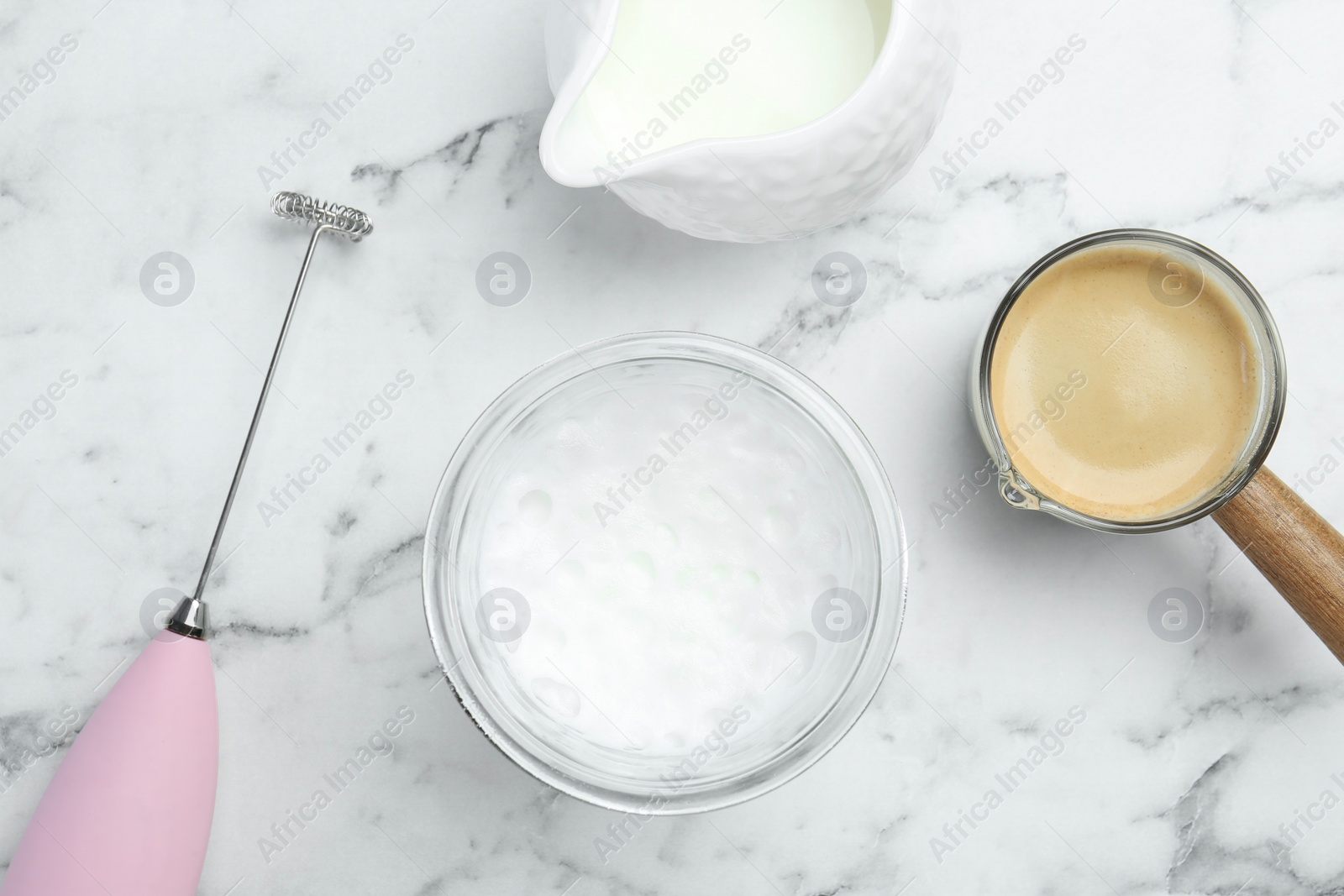 Photo of Flat lay composition with mini mixer (milk frother), whipped milk in glass and coffee at white marble table