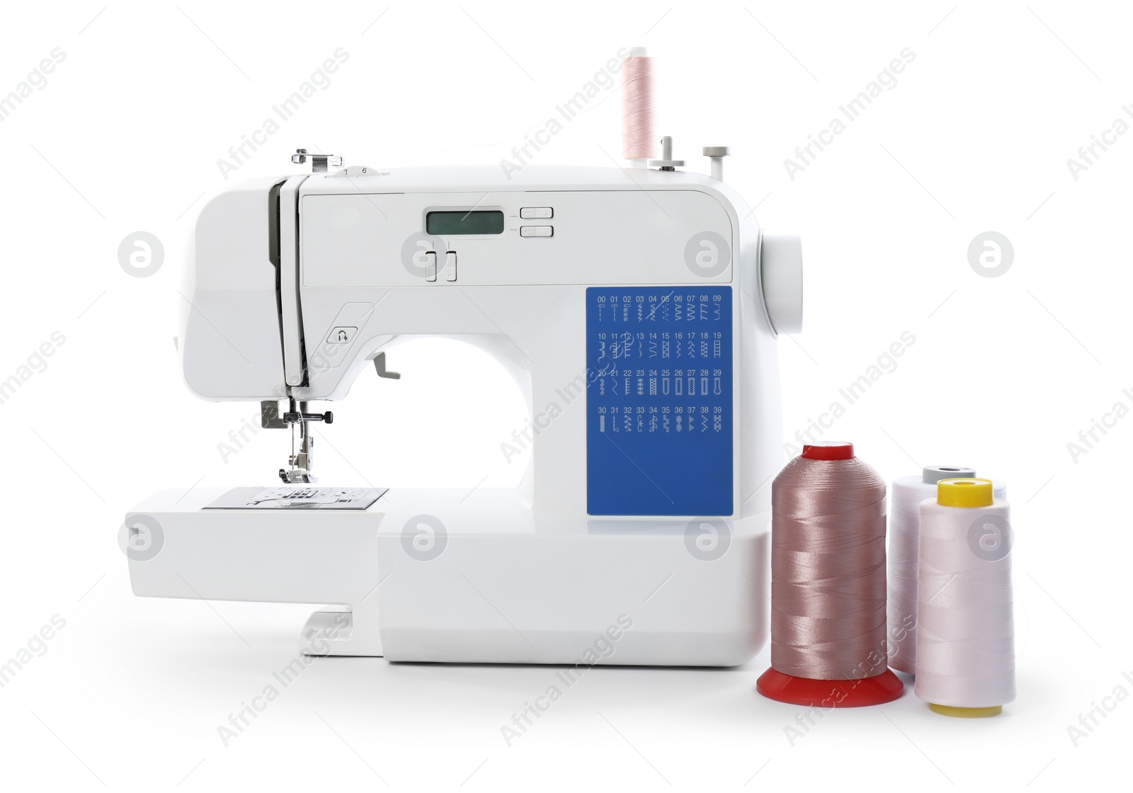 Photo of Sewing machine and spools of threads isolated on white