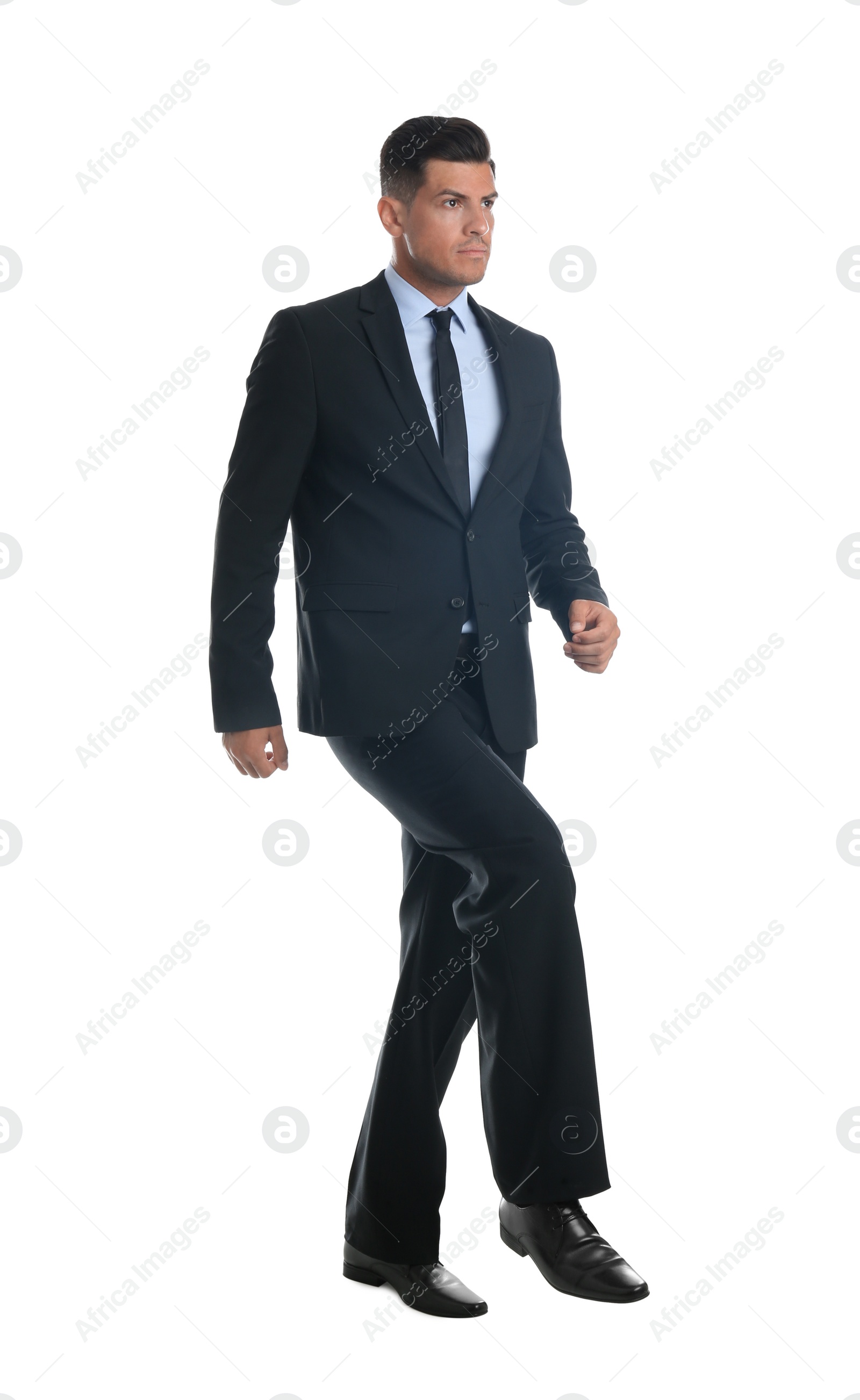 Photo of Businessman imitating stepping up on stairs against white background. Career ladder concept