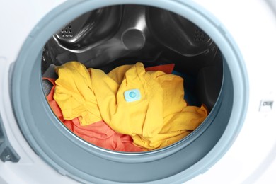 Photo of Water softener tablet on clothes in washing machine