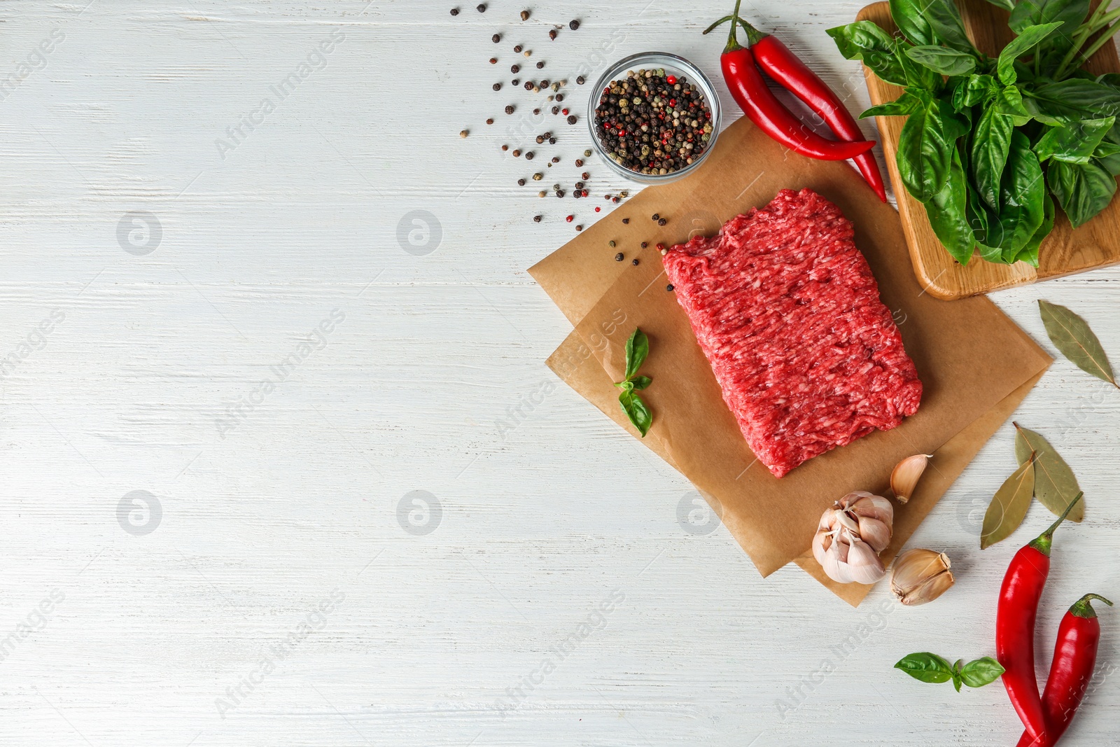 Photo of Flat lay composition with fresh raw minced meat on white wooden table. Space for text