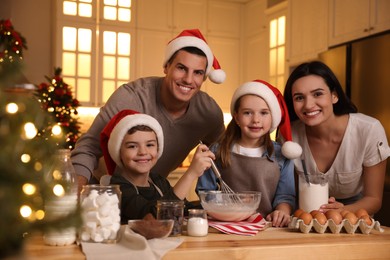 Happy family making dough for delicious Christmas cookies at home