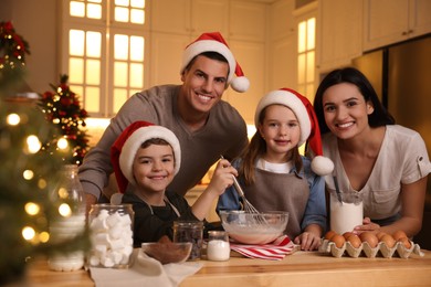 Photo of Happy family making dough for delicious Christmas cookies at home