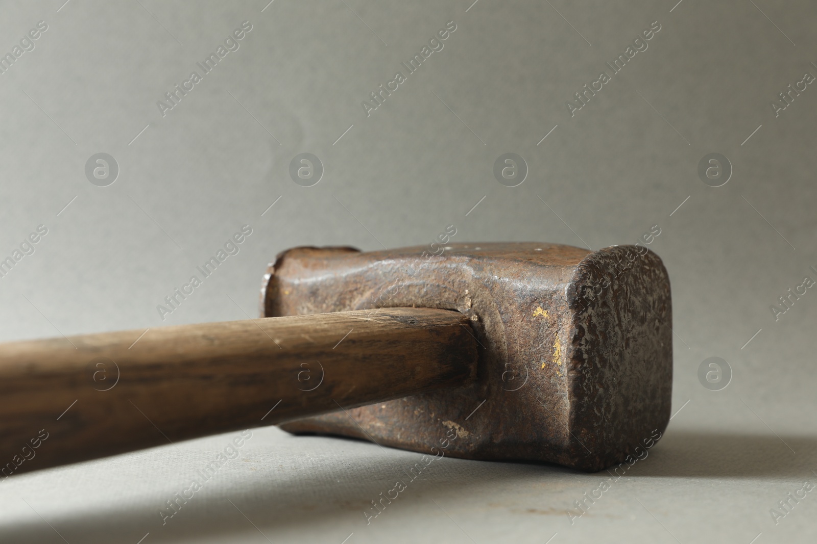 Photo of One sledgehammer on grey background, closeup. Manual tool