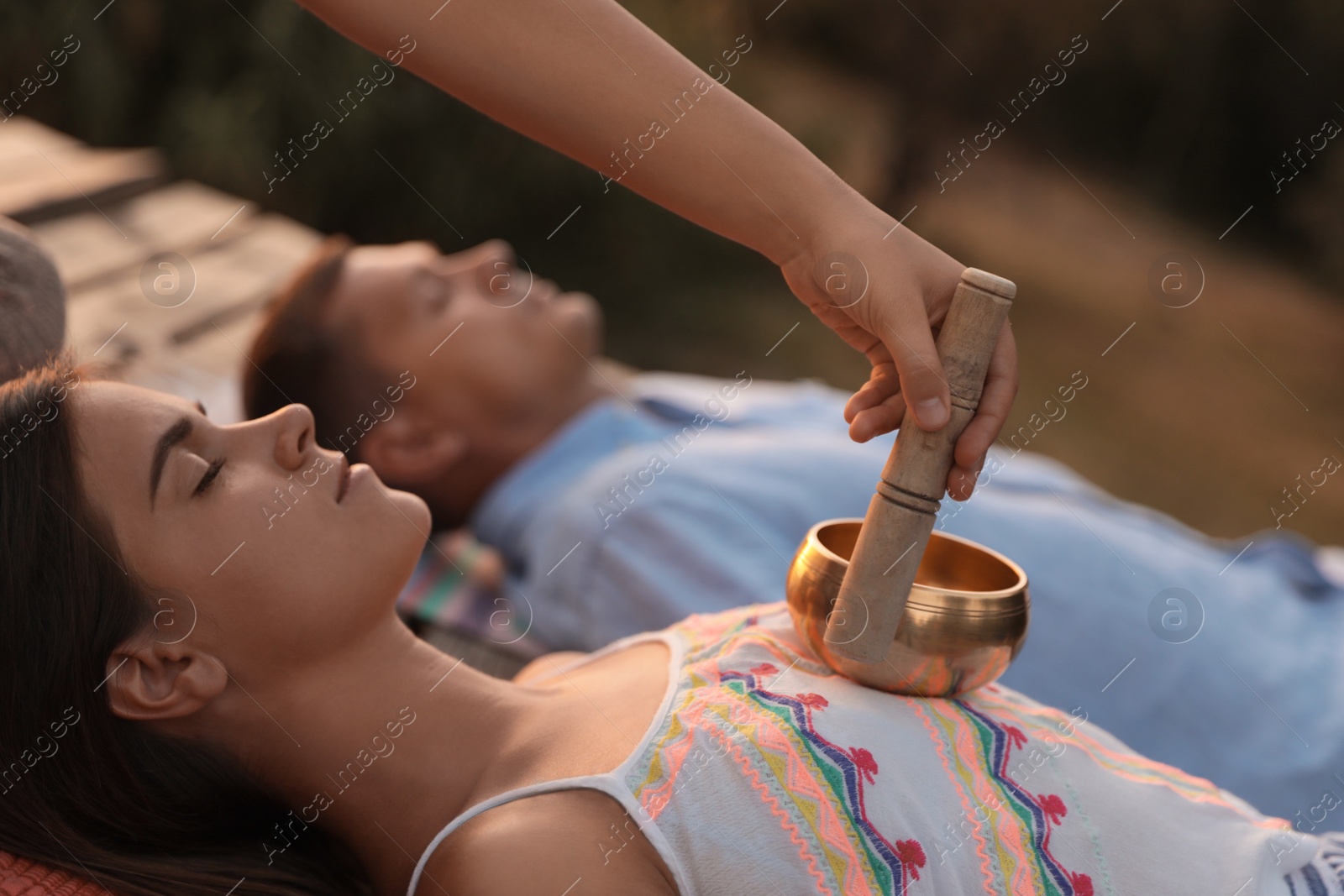 Photo of Couple at healing session with singing bowl outdoors