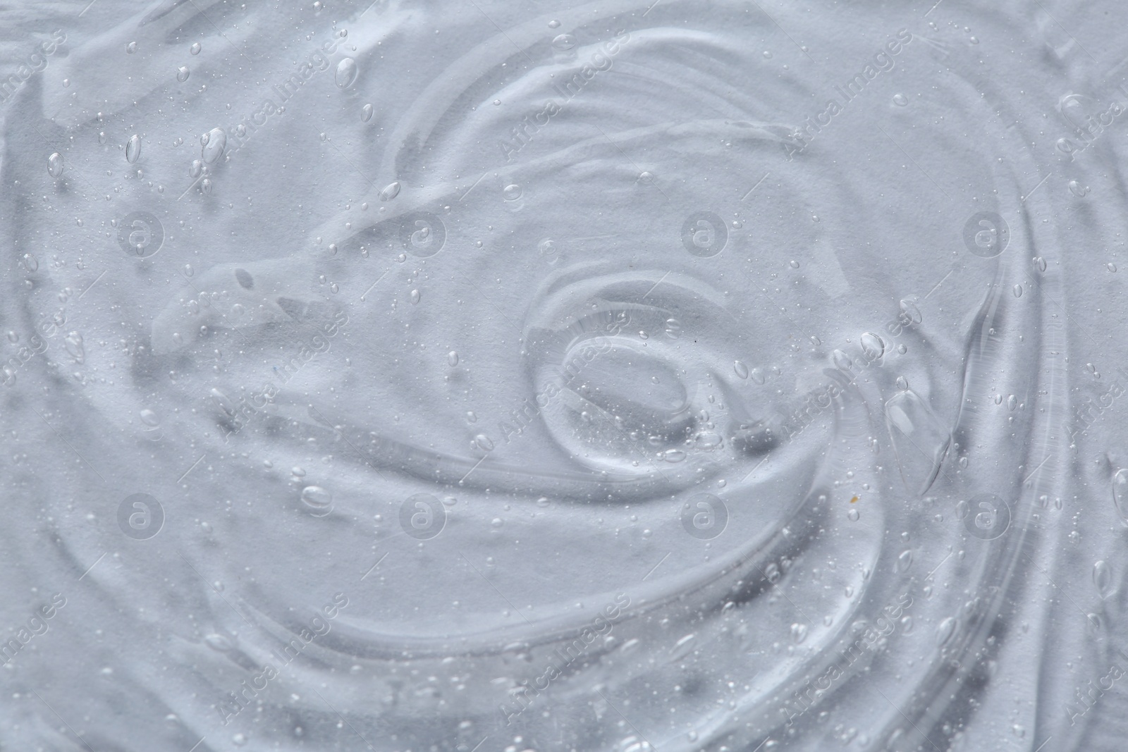 Photo of Clear cosmetic serum on white background, macro view