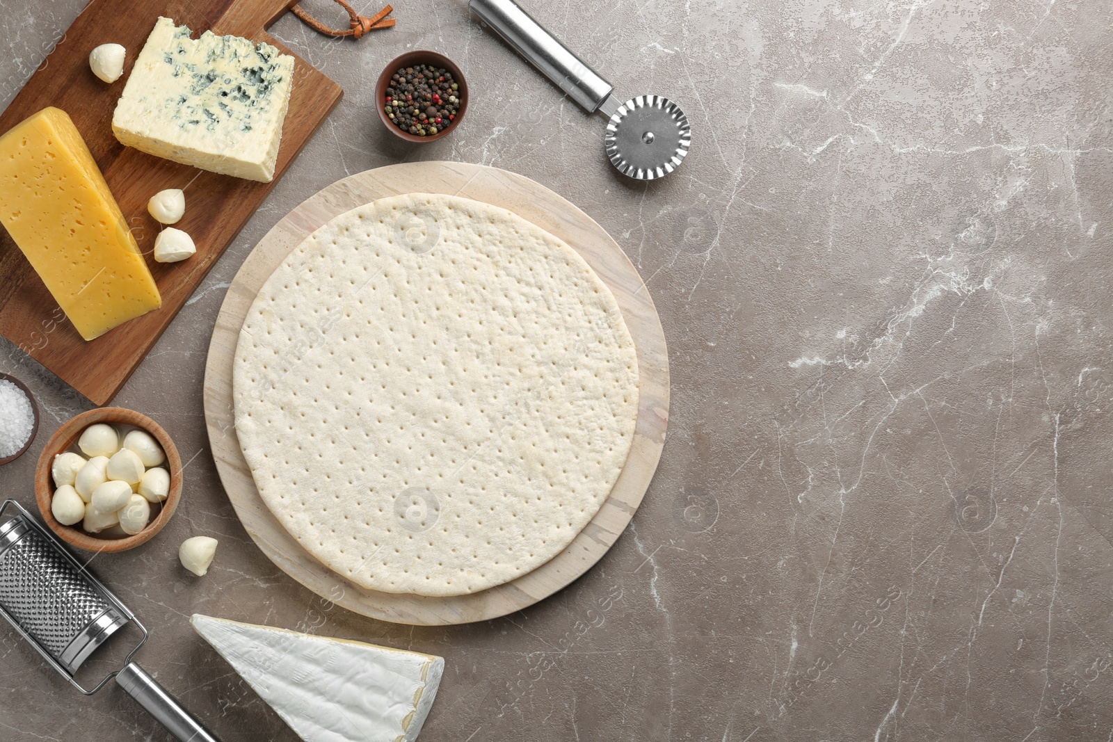 Photo of Flat lay composition with pizza crust and fresh ingredients on table. Space for text