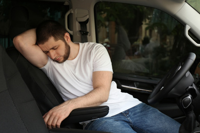 Tired man sleeping in his modern car