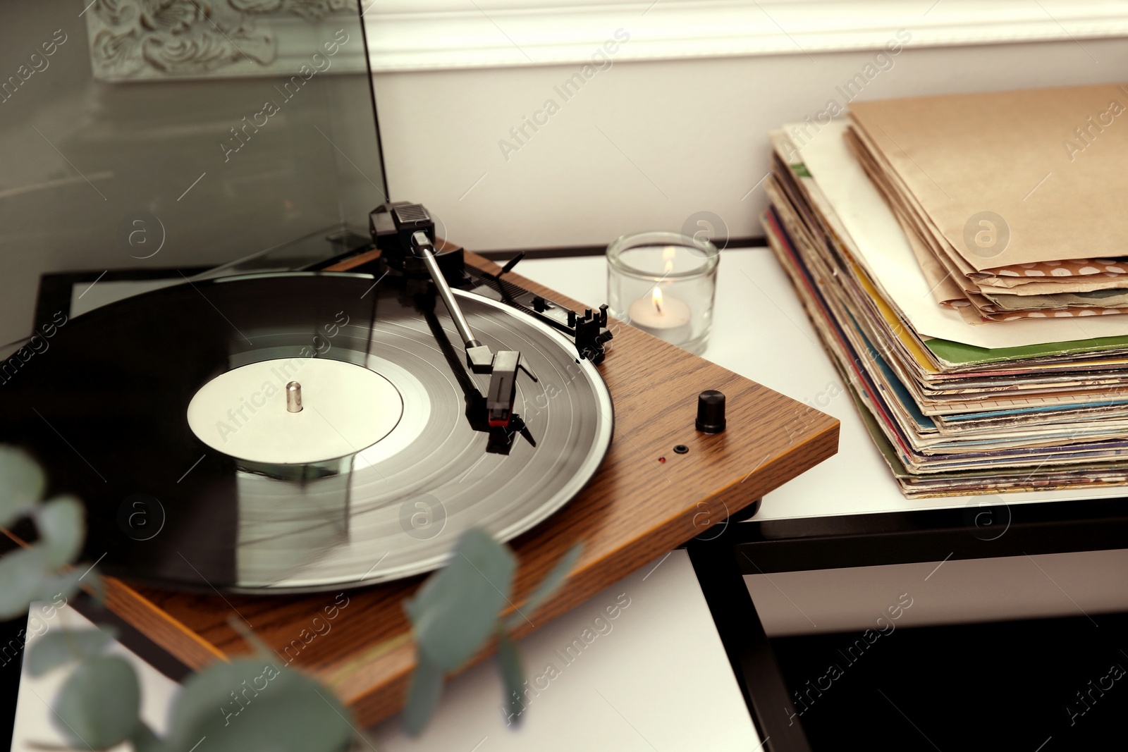 Photo of Stylish turntable with vinyl record on table indoors