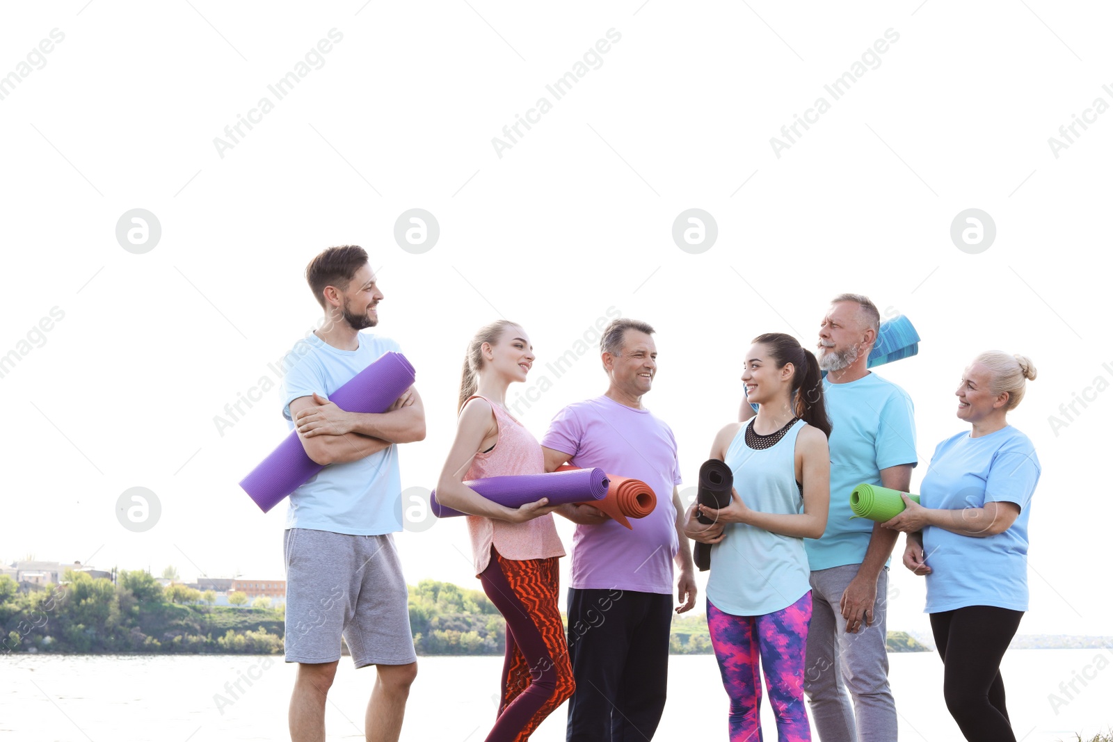 Photo of Group of people talking after yoga class near river on sunny day