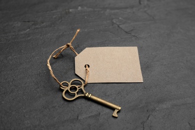 Photo of Vintage key with blank tag on black table. Keyword concept