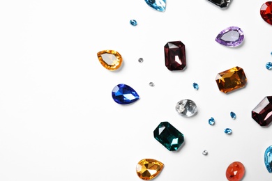 Different beautiful gemstones on white background, top view