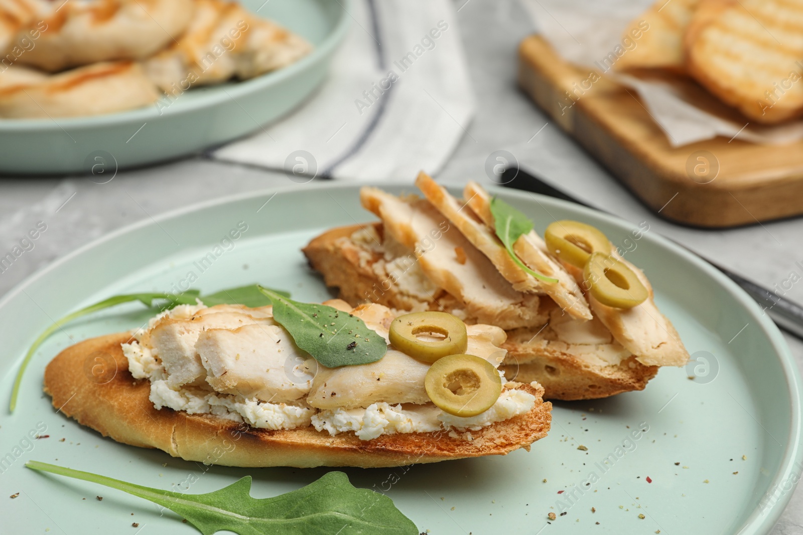 Photo of Plate of delicious chicken bruschettas on table