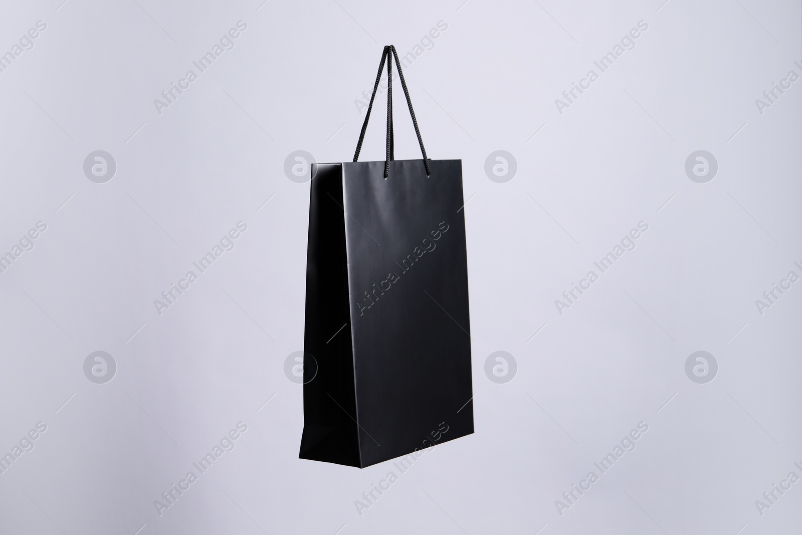 Photo of One black paper shopping bag on grey background