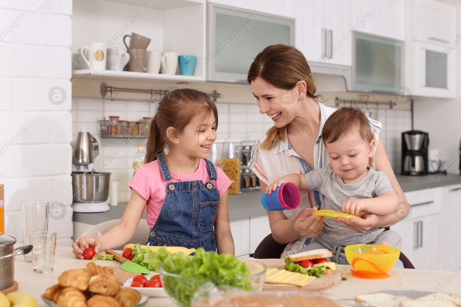 Photo of Housewife preparing dinner with her children on kitchen