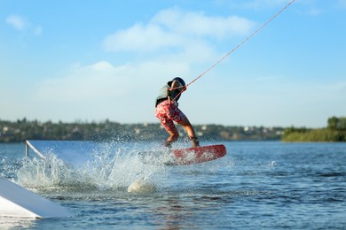 Teenage wakeboard doing trick on river. Extreme water sport