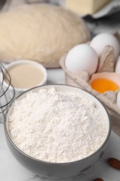 Bowl with flour on white marble table, closeup