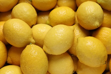 Fresh lemons with water drops as background, closeup